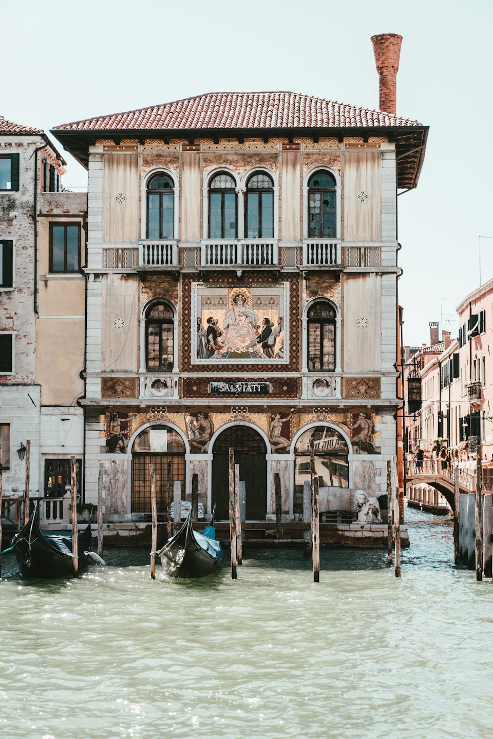 Facciata di palazzo veneziano con gondole sul canale.