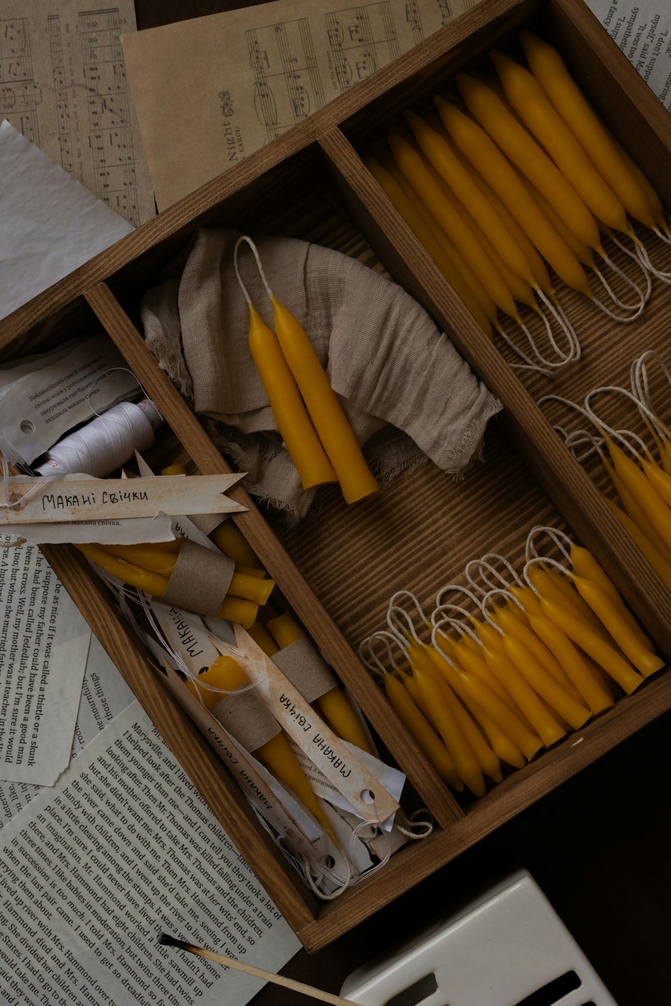 Candele gialle di cera d'api fatte a mano disposte in un vassoio di legno.